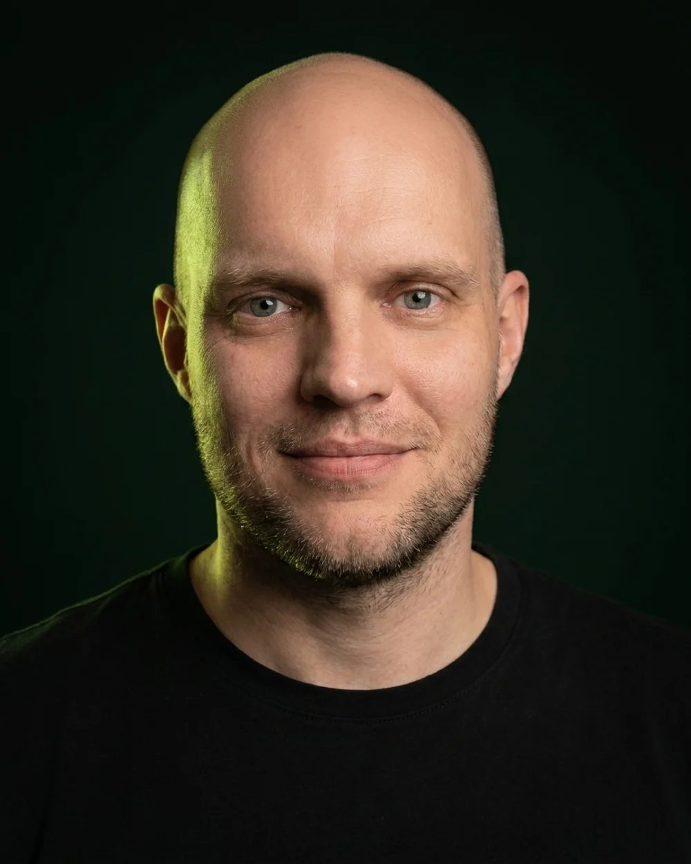 Porträt von Sven Stange vor dunklem Hintergrund mit grünem Streiflicht (professionell nachbearbeitetes Foto)